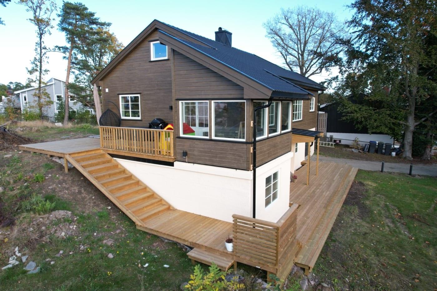 Brunt hus med ny terrasse og rampe